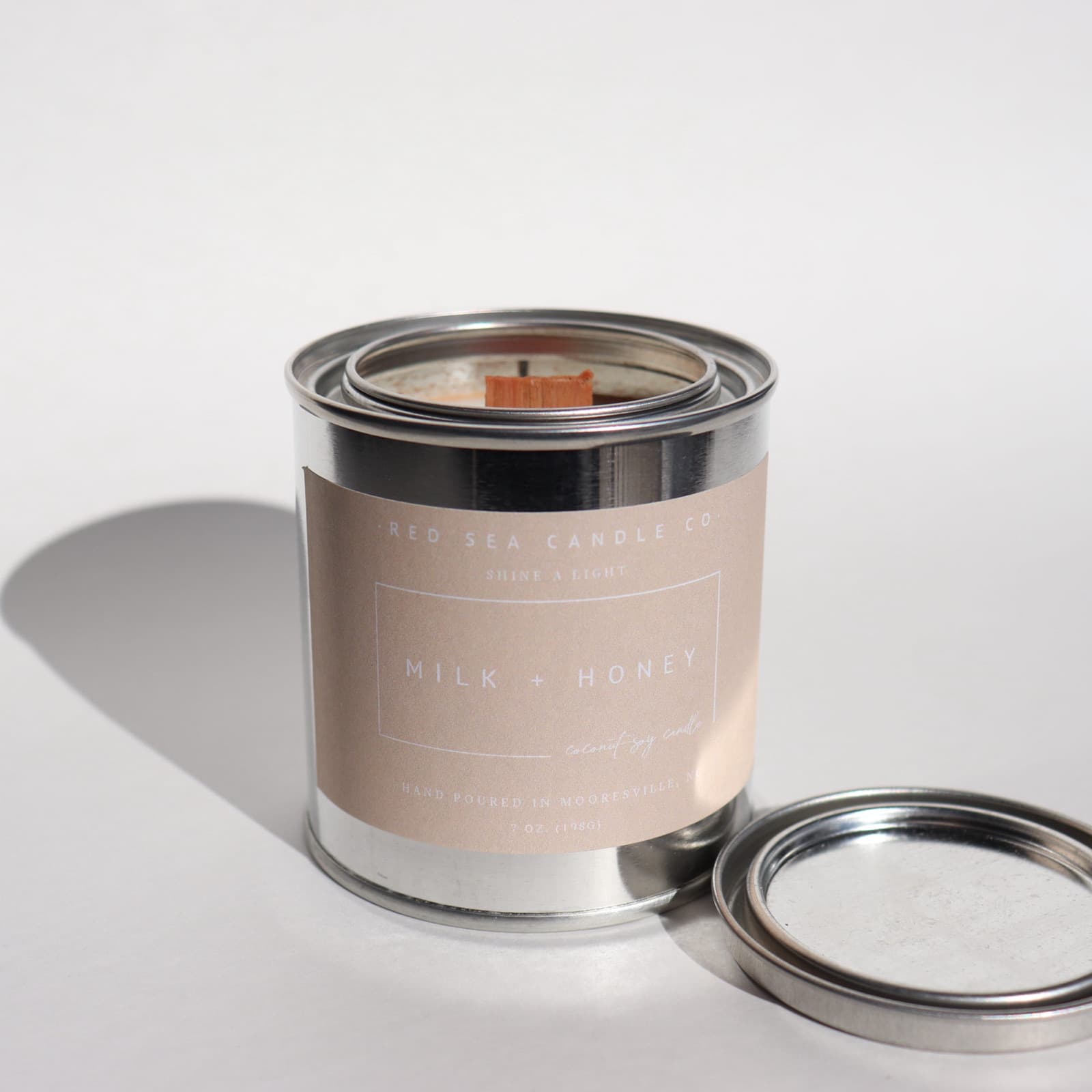 A Milk + Honey candle tin with the lid off